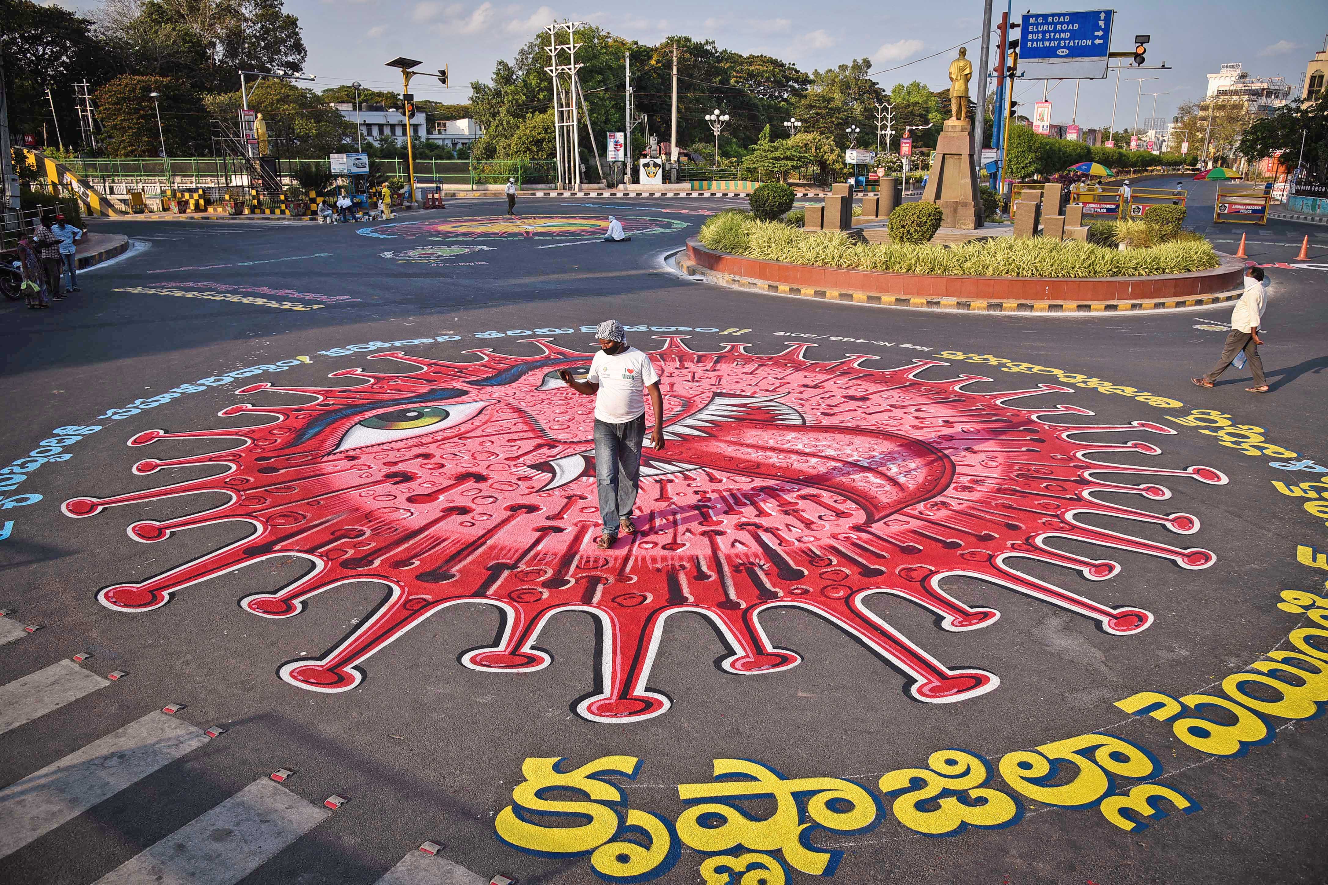 A graffiti made on a road depicting the Coronavirus as an attempt to raise awareness about the importance of staying at home during an extended nationwide lockdown to slow the spread of coronavirus, at Control room center in Vijayawada on Sunday.